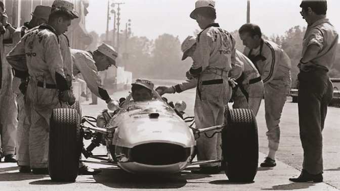 Hondas Formel 1-bil fra 60-tallet med racerfører og ingeniører, sett forfra.