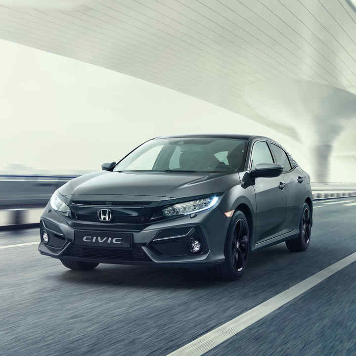 Honda Civic 5-dørs sett skrått forfra som kjører i kupert landskap