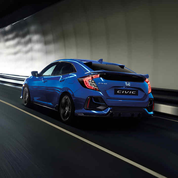 Honda Civic 5-dørs som kjører gjennom tunnel, sett skrått bakfra.