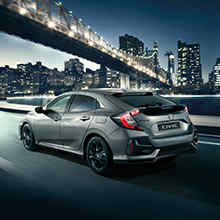 Honda Civic 5-dørs sett skrått bakfra mens den kjører gjennom byen