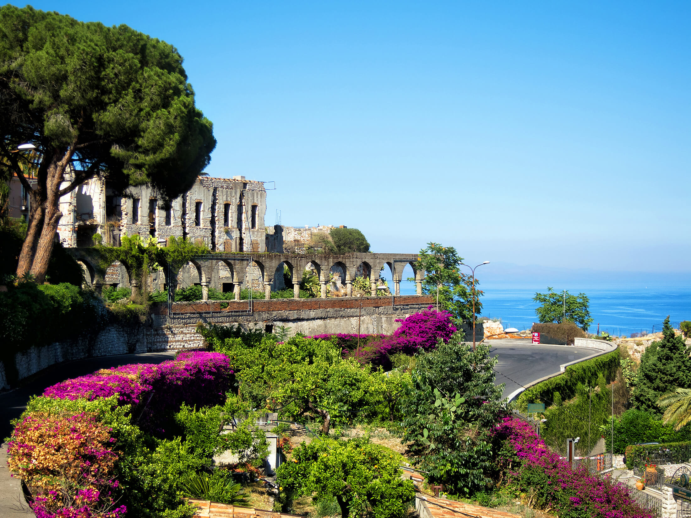 En fargerik hage nær en gammel bygning på Sicilia, Italia