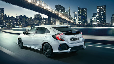 Honda Civic Dynamic sett skrått bakfra, mens den kjører gjennom byen.