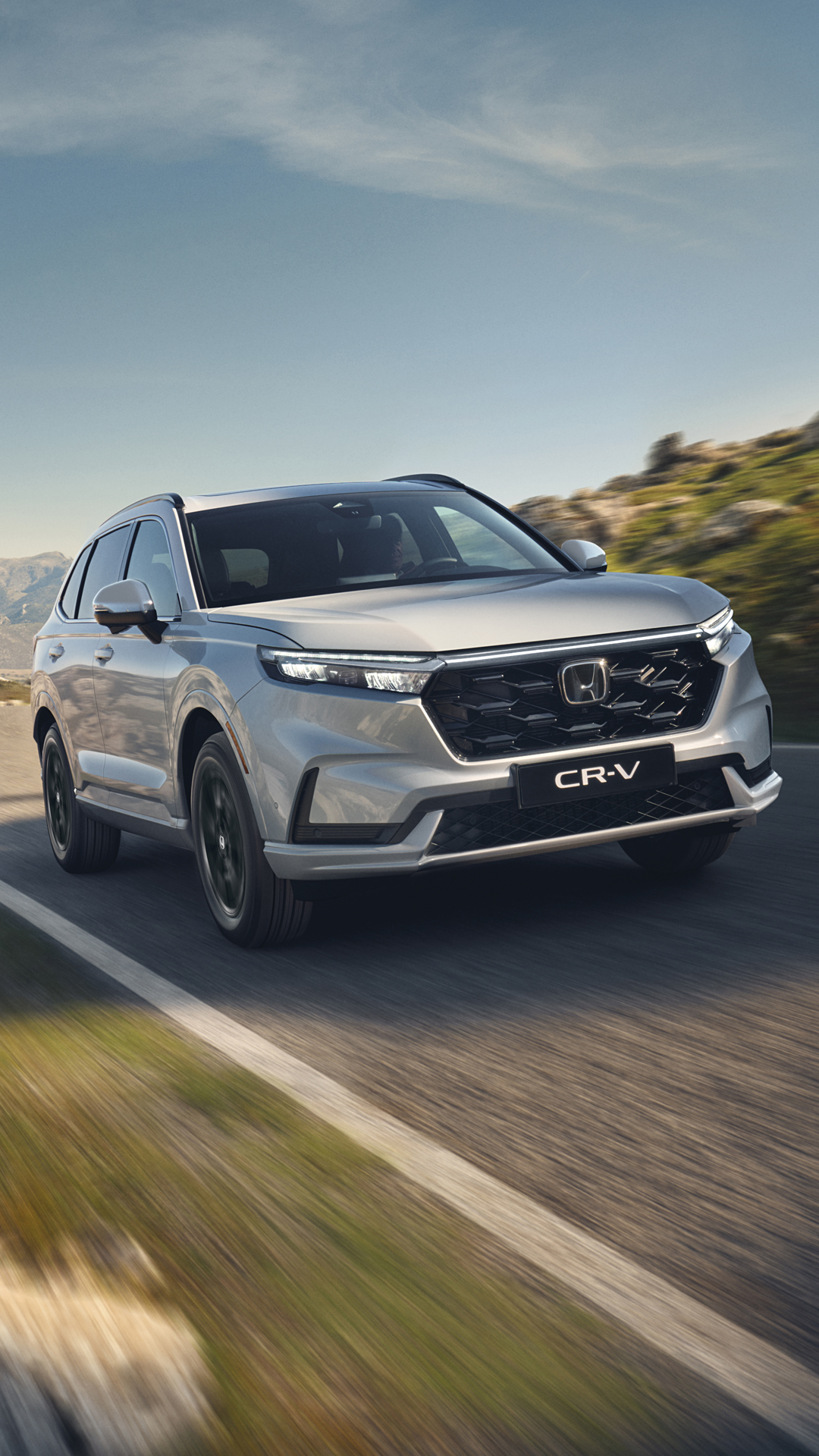 CR-V Plug in Hybrid Suv car driving on the road in a mountain location.