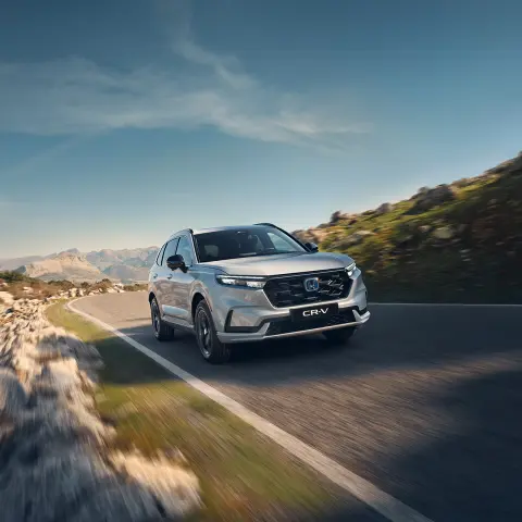 CR-V plug-in Hybrid SUV som kjører på veien i fjellet.