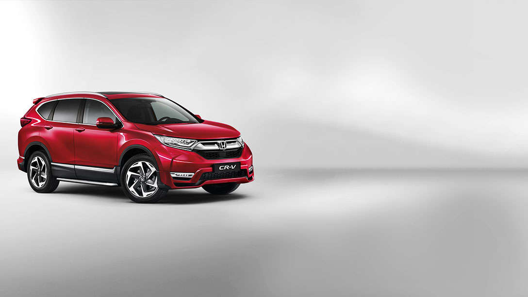 Rød Honda CR-V i studiomiljø sett fra siden.