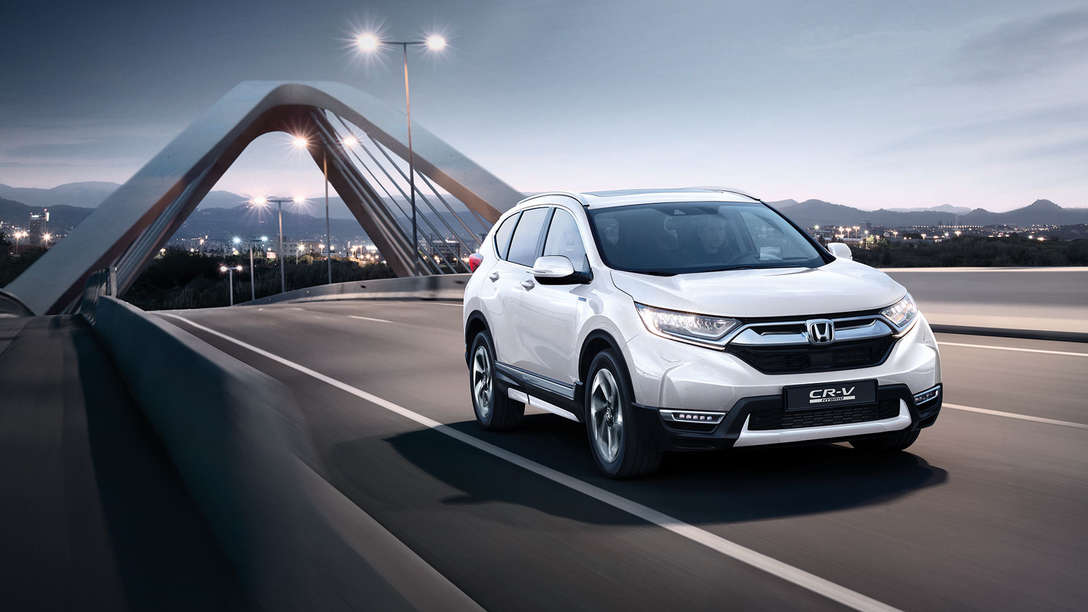 Honda CR-V Hybrid sett skrått forfra i gatemiljø.