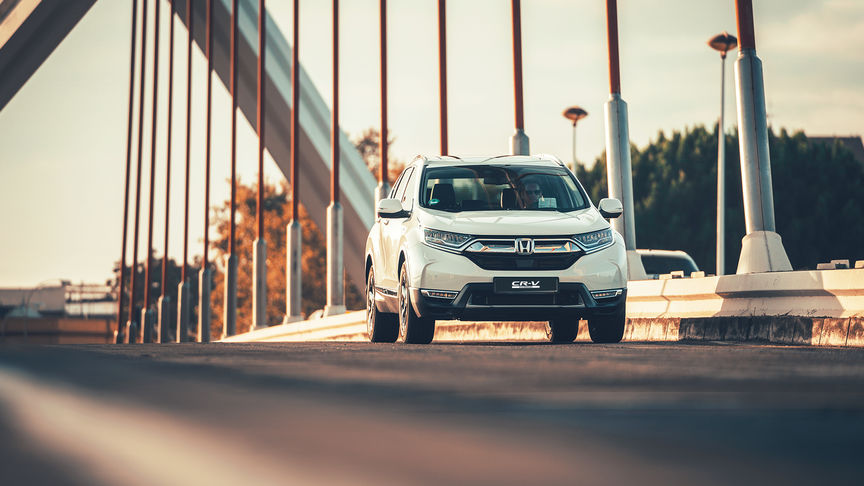 Tre-fjerdedels front mot Honda CR-V Hybrid bil i gatemiljø.