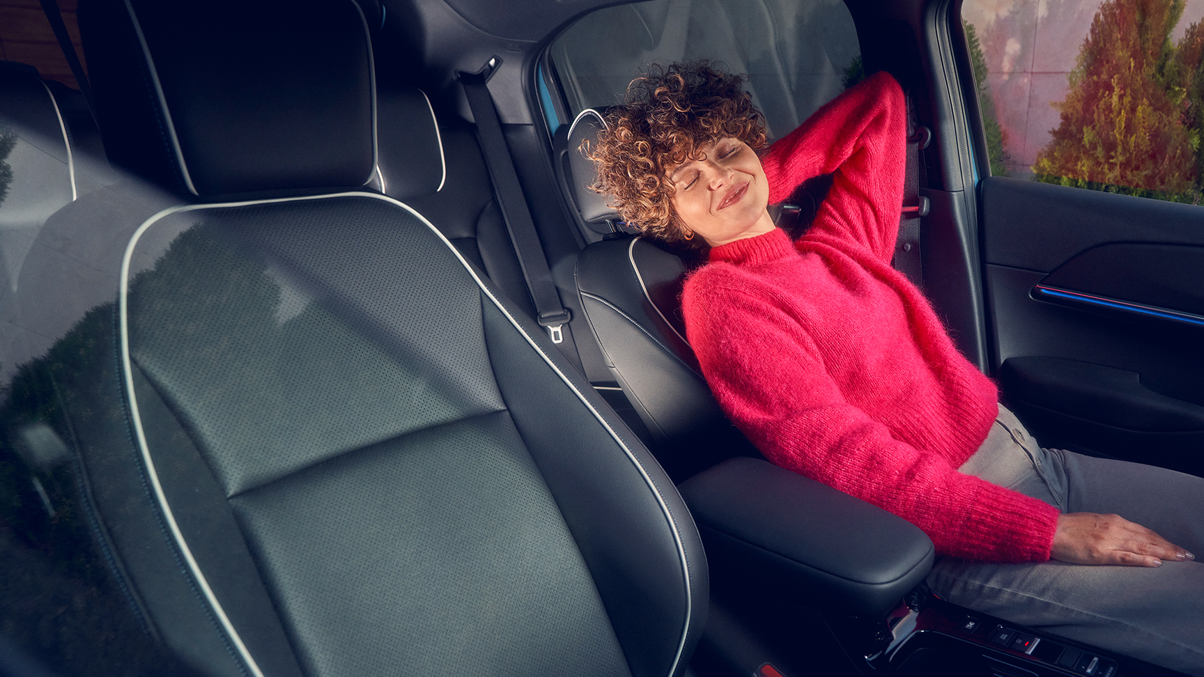 Kvinne tilbakelent i førersetet på Honda e:NY1.