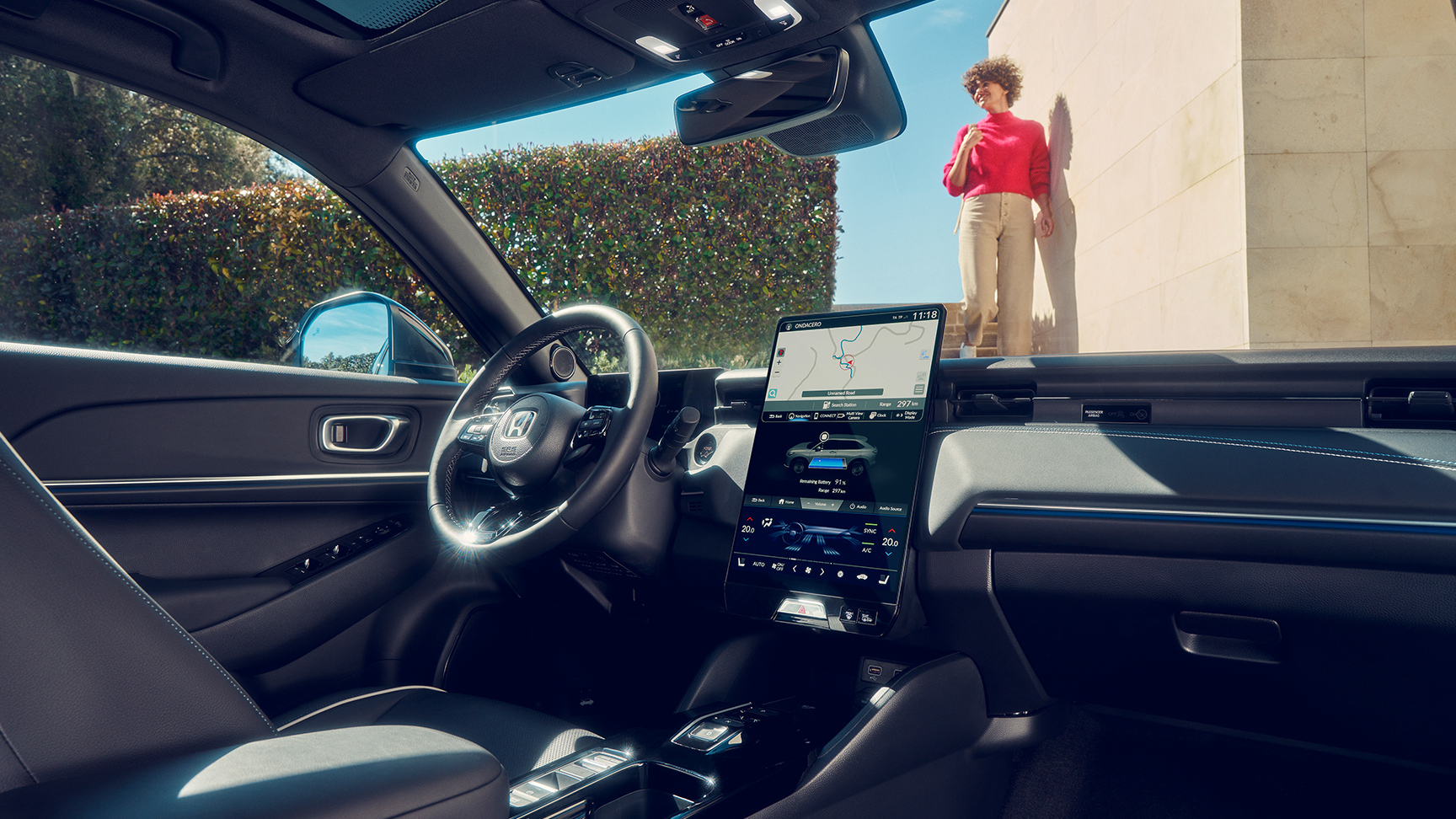 Full oversikt over dashbordet med kvinne sett gjennom frontruten. 