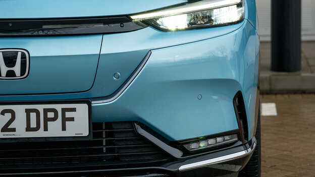 Nærbilde av parkert blå Honda e:Ny1-bil.