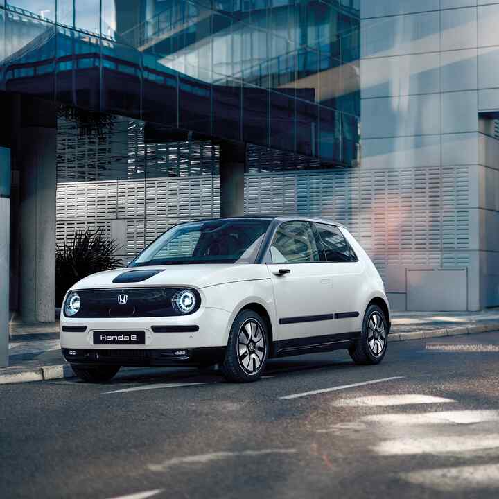 Honda e i gate med bygninger i bakgrunnen
