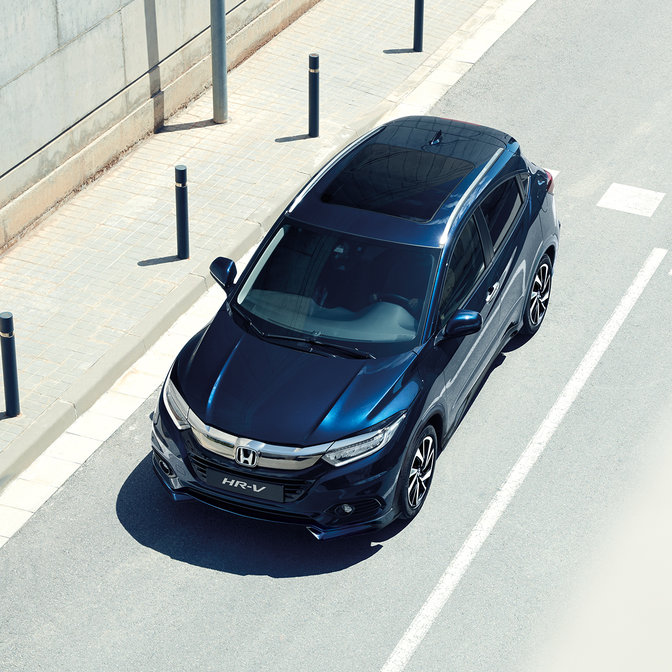 Sidevisning ovenfra av Honda HR-V i bymiljø.
