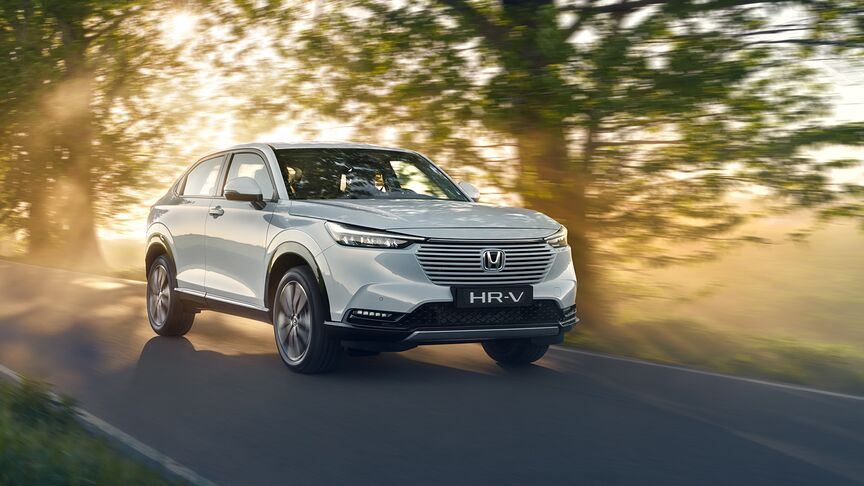 Skråvisning av HR-V Hybrid som kjører gjennom et landskap