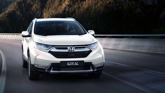 Honda CR-V som kjører gjennom fjellområde, sett forfra.