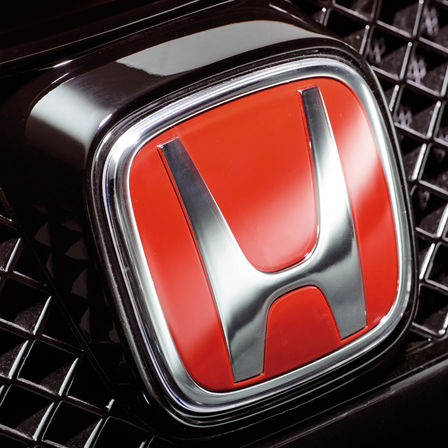 Nærbilde av Hondas røde «H»-logo.